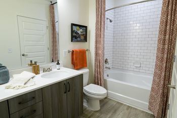 A bathroom with a sink toilet and a bath tub at the eddy at riverview, smyrna, georgia